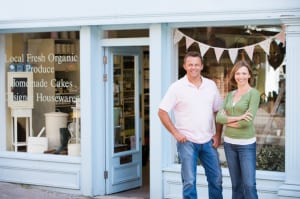 Couple standing in front of organic food store smiling